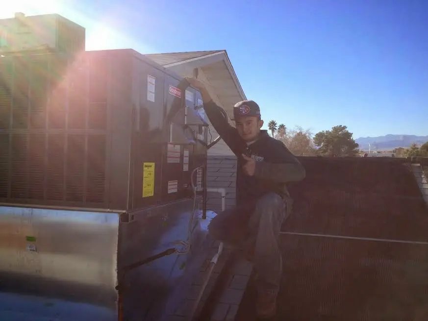 HVAC technician performing Air Duct Repair on a rooftop unit in Sauk Village